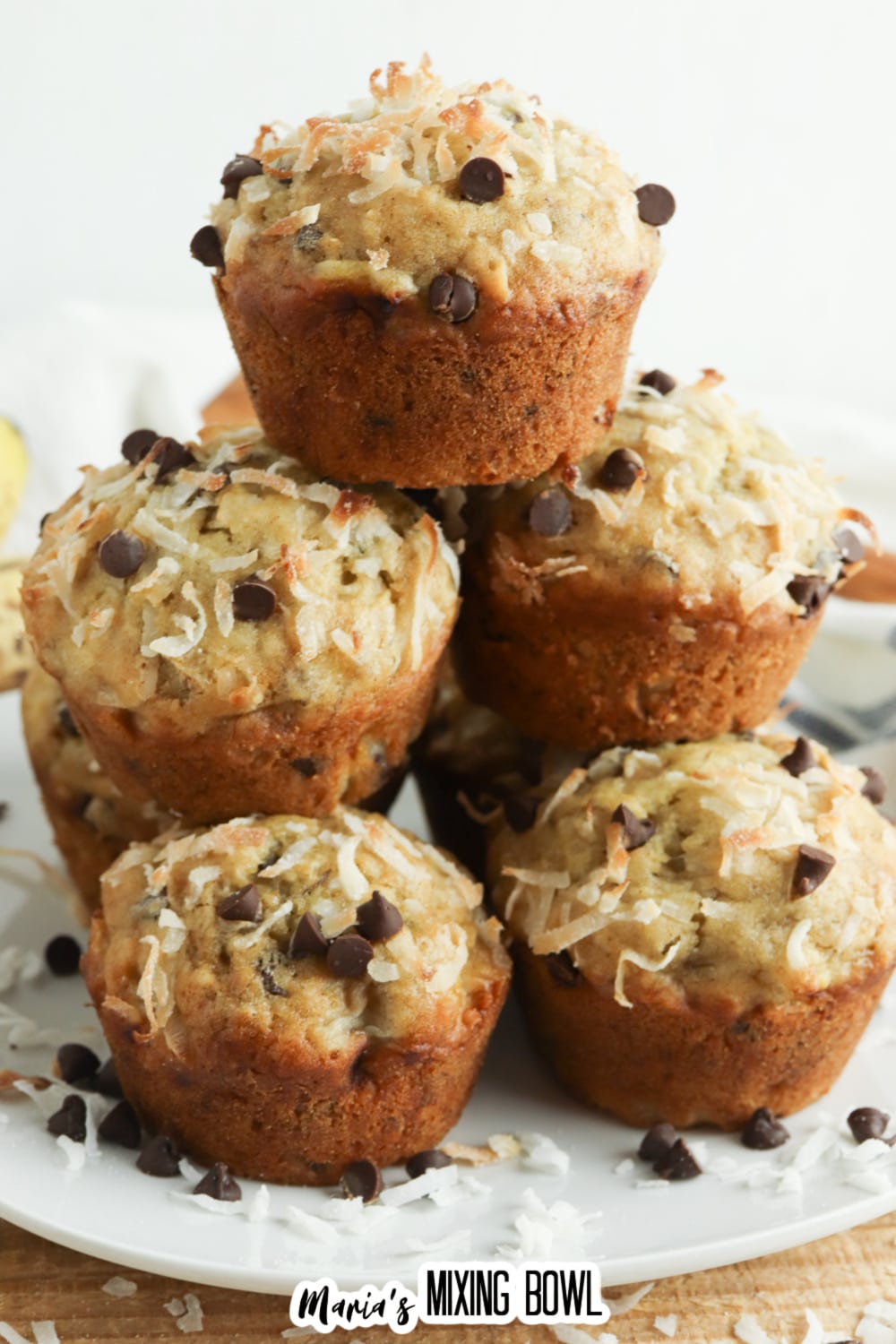 stack of banana coconut muffins on a plate.