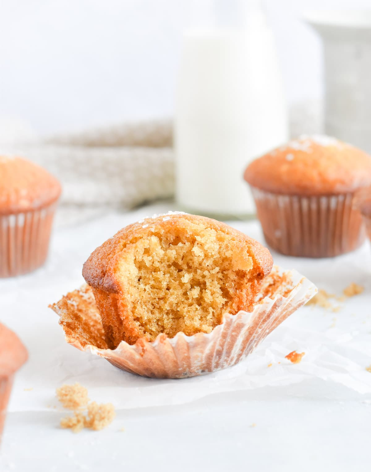 muffin with bite out of it sitting in its muffin paper. 