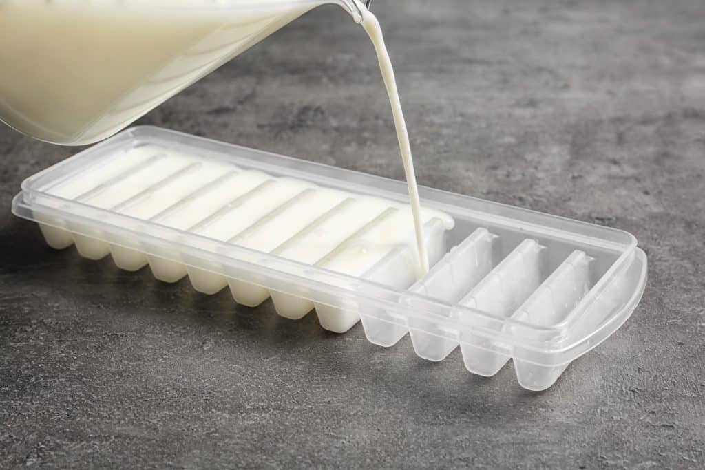 pouring milk into a cube tray