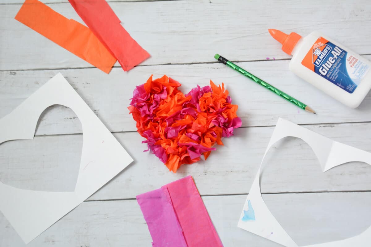 textured heart with tissue paper and supplies around it.