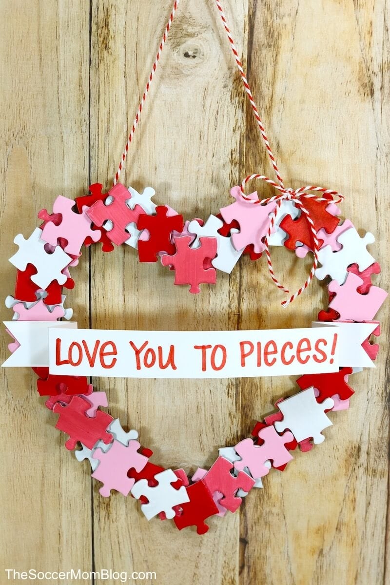 This adorable DIY Valentine Wreath is an easy and thrifty Valentine's Day craft to make with kids. All you need is a dollar store puzzle, a recycled cardboard box, and simple art supplies! 